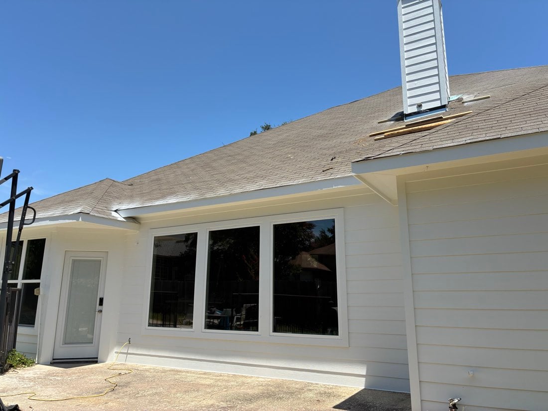 Patio door and large picture window unit on a white siding wall at the rear of an Austin TX home