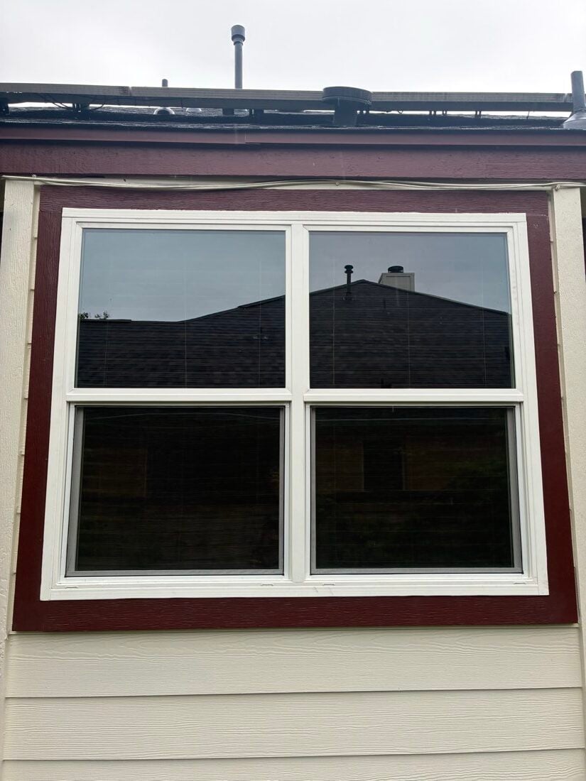 New white double-hung twin window unit set in dark red trim on an Austin TX home