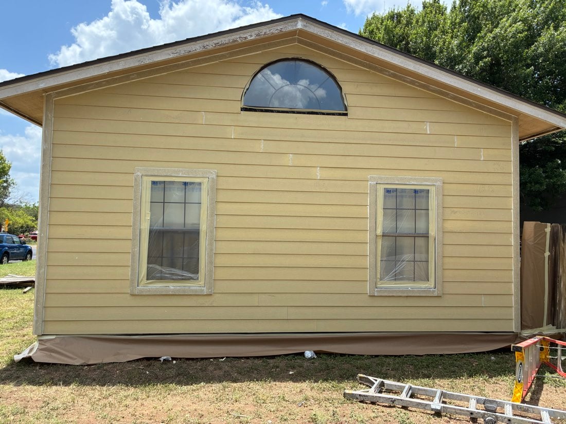 New windows with factory film on the glass and an arch transom during installation on an Austin TX home