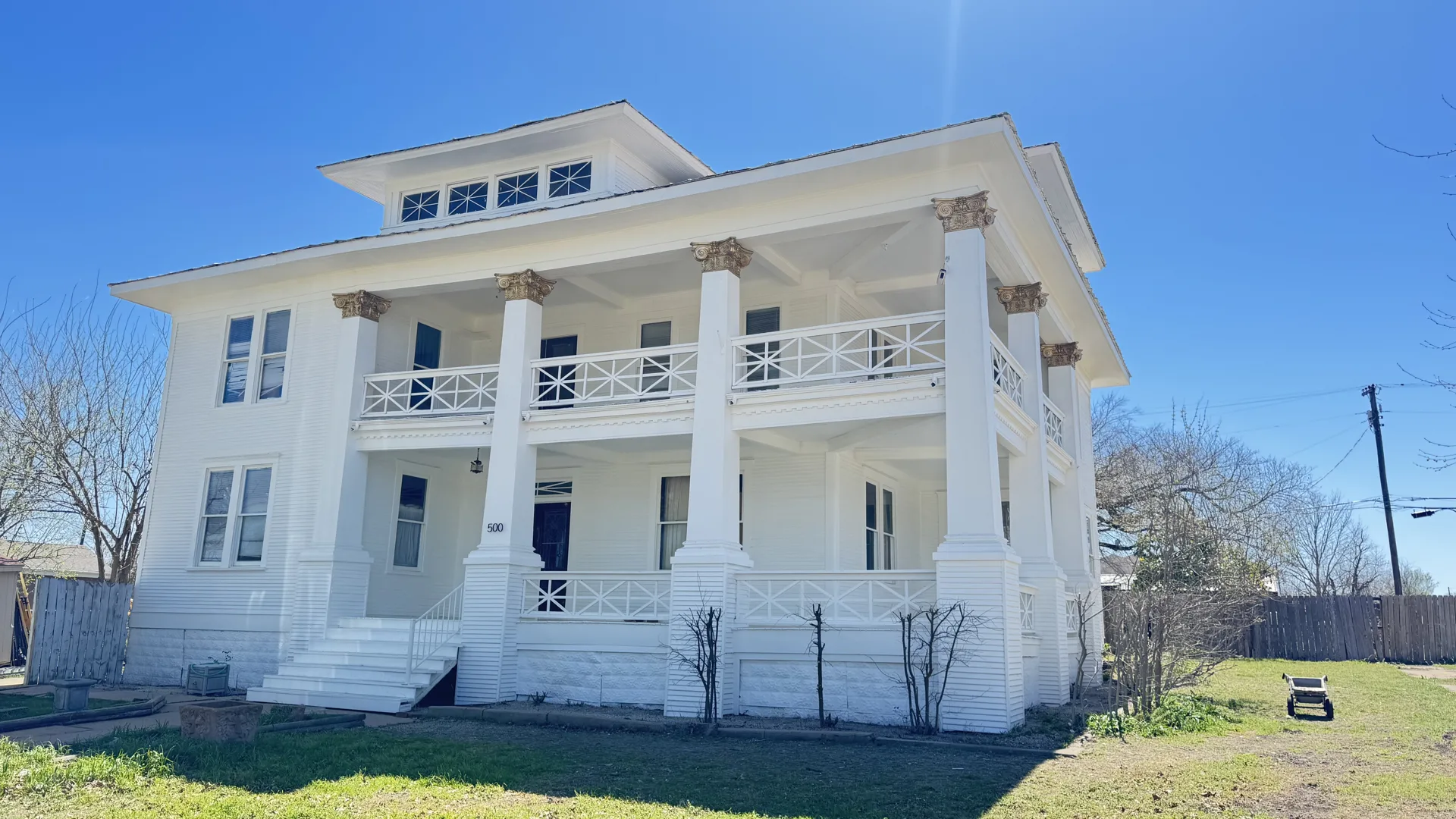 White two-story home with upper and lower porches