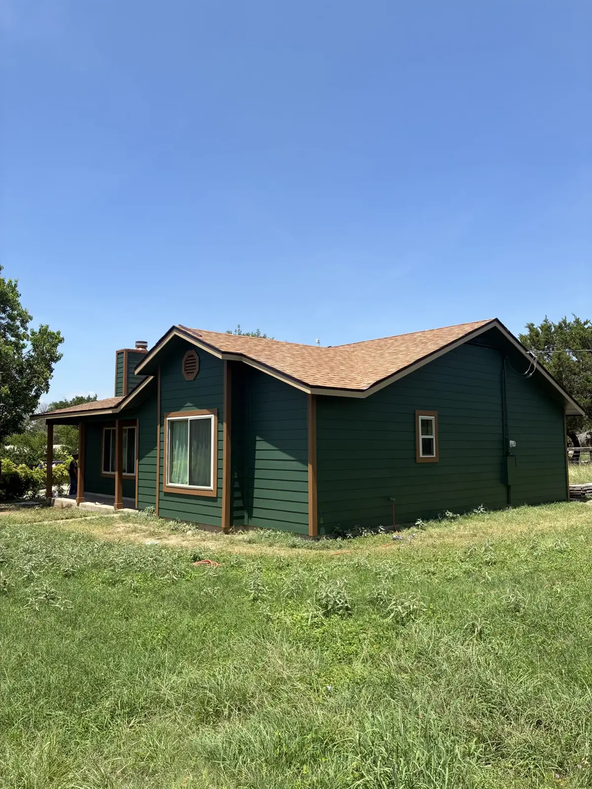 Green horizontal siding and a tan shingle roof
