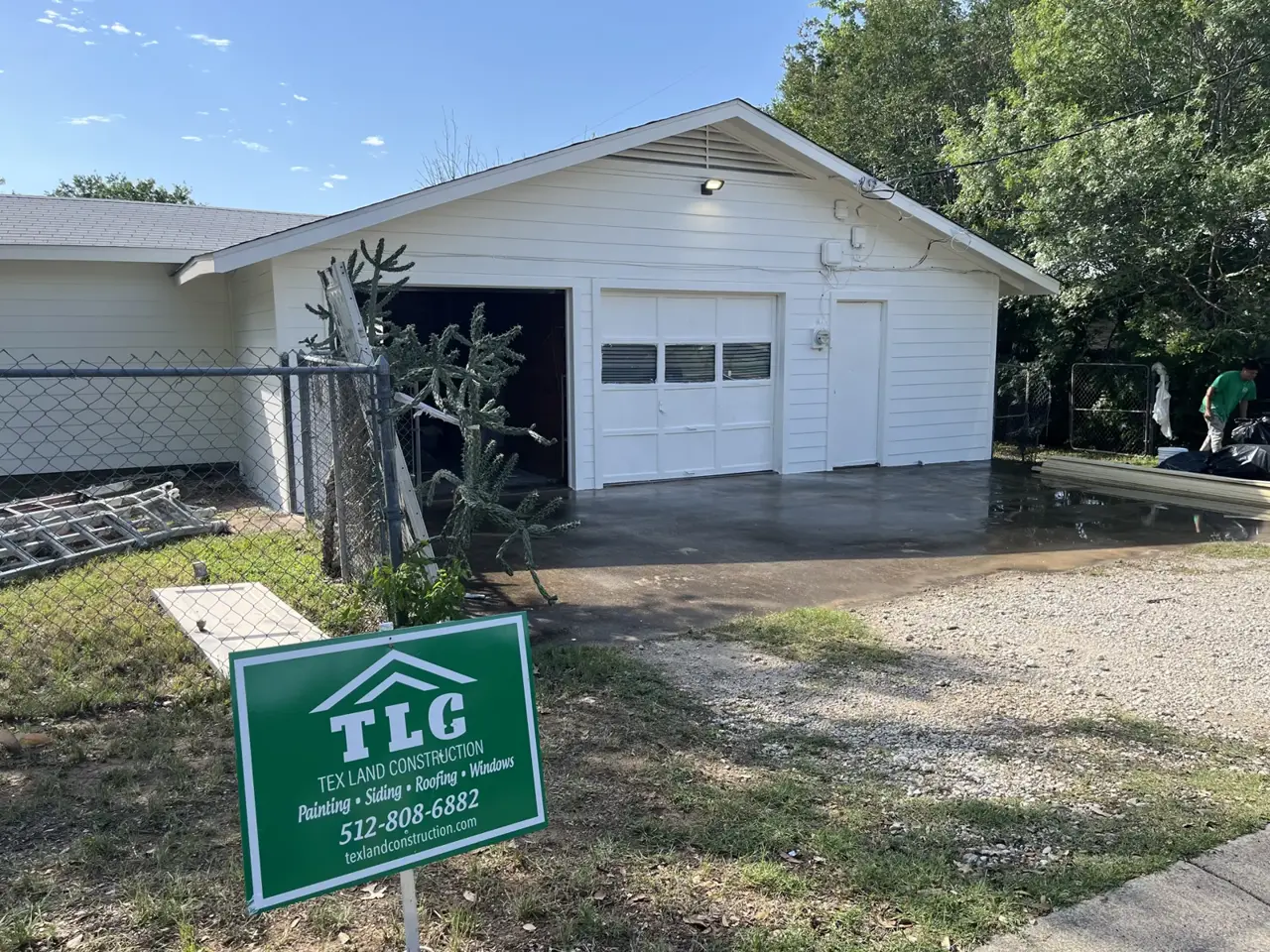 White sided garage with a Tex Land Construction sign
