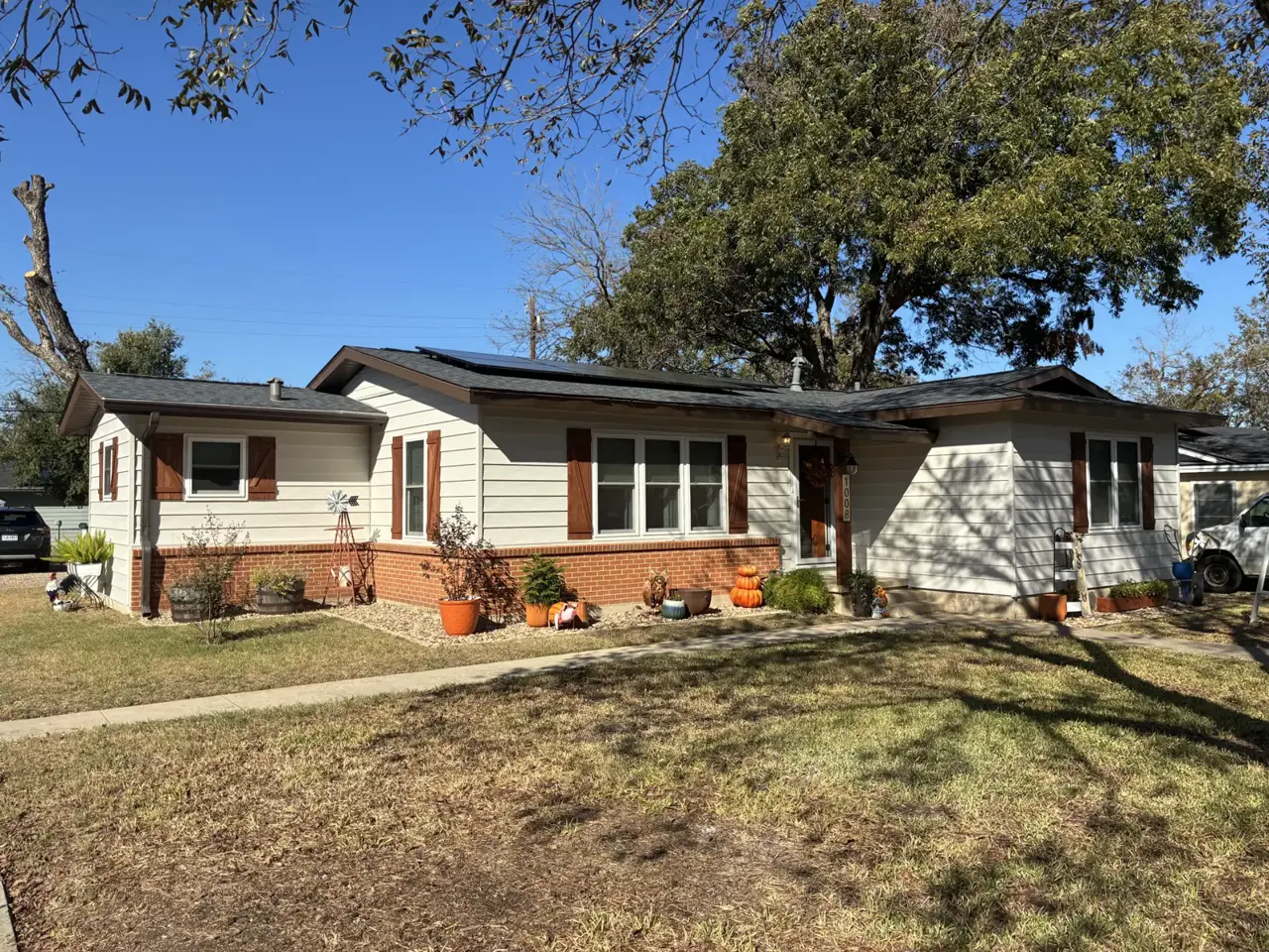 Light horizontal siding with red shutters and brick accents