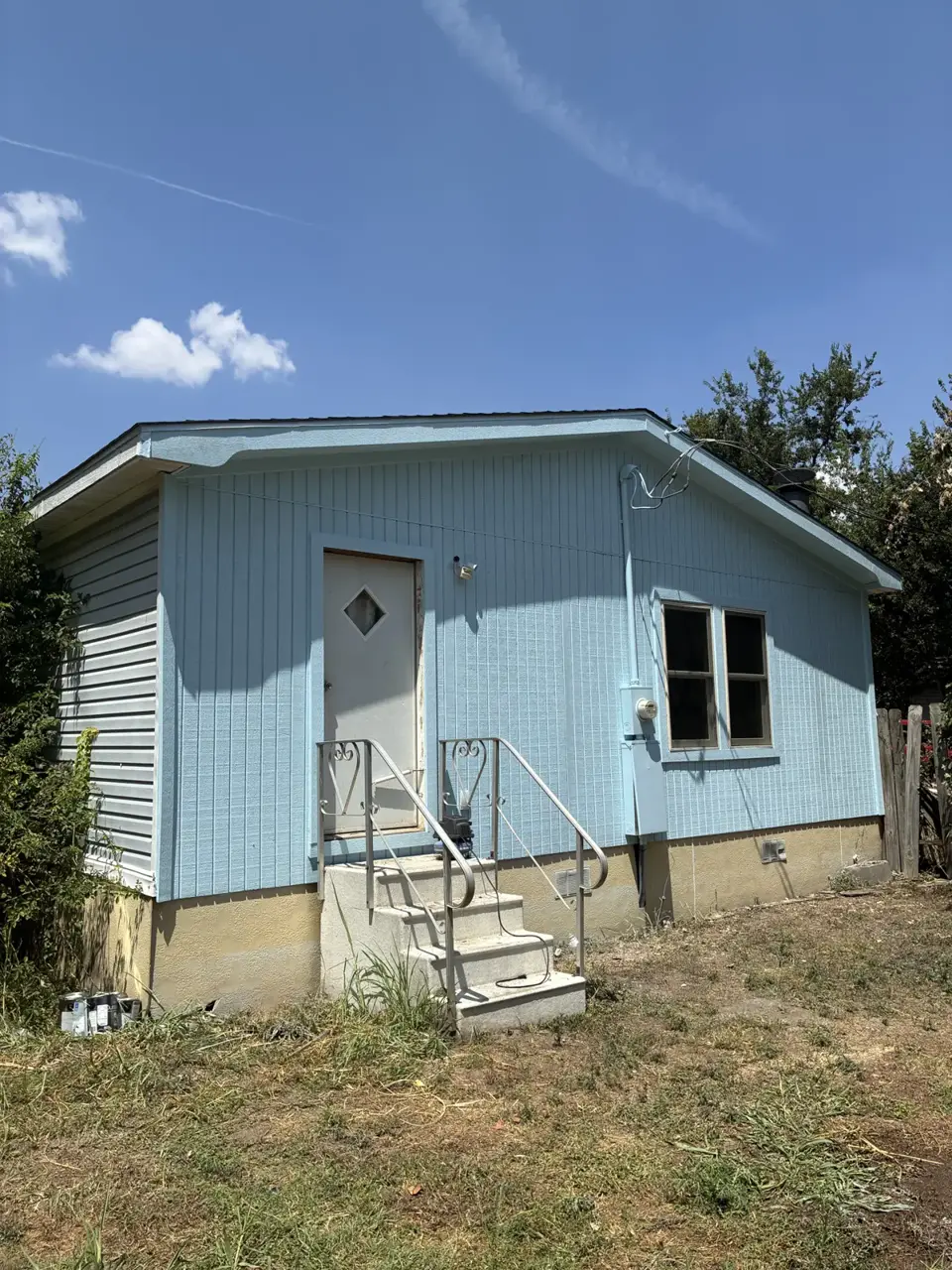 Light blue vertical siding on a small house