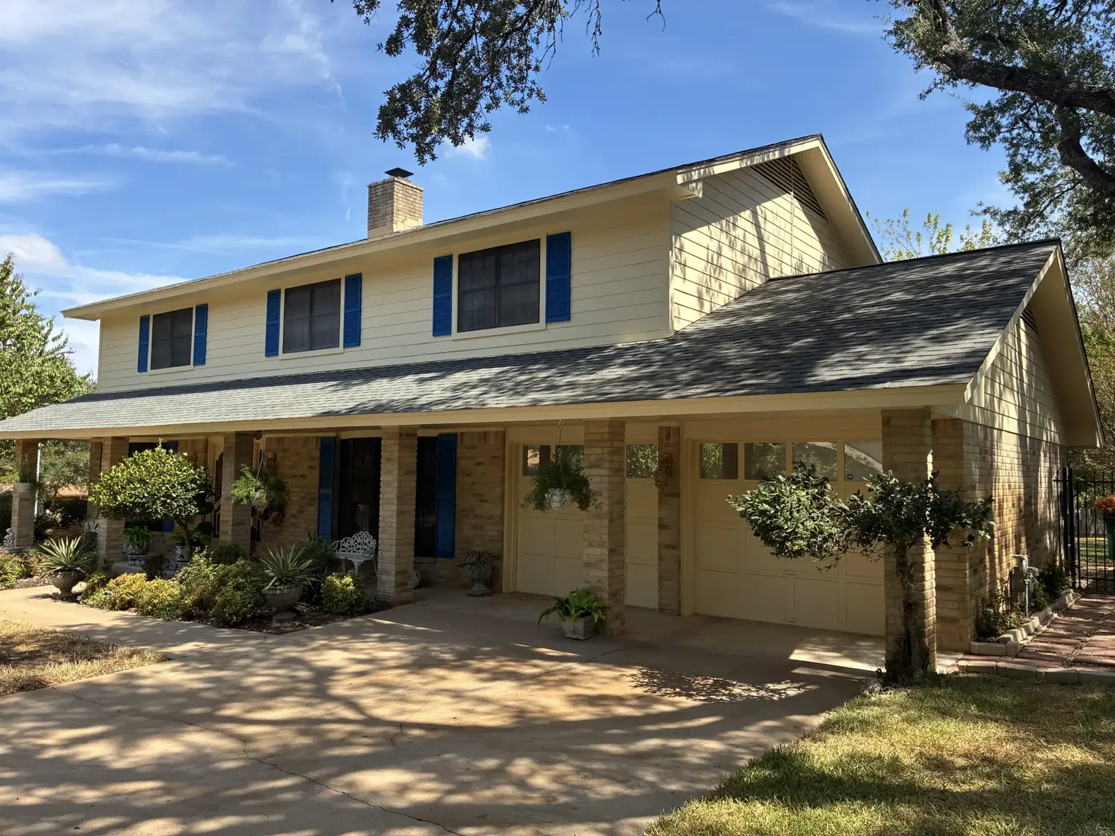 Two-story yellow home with dark shutters