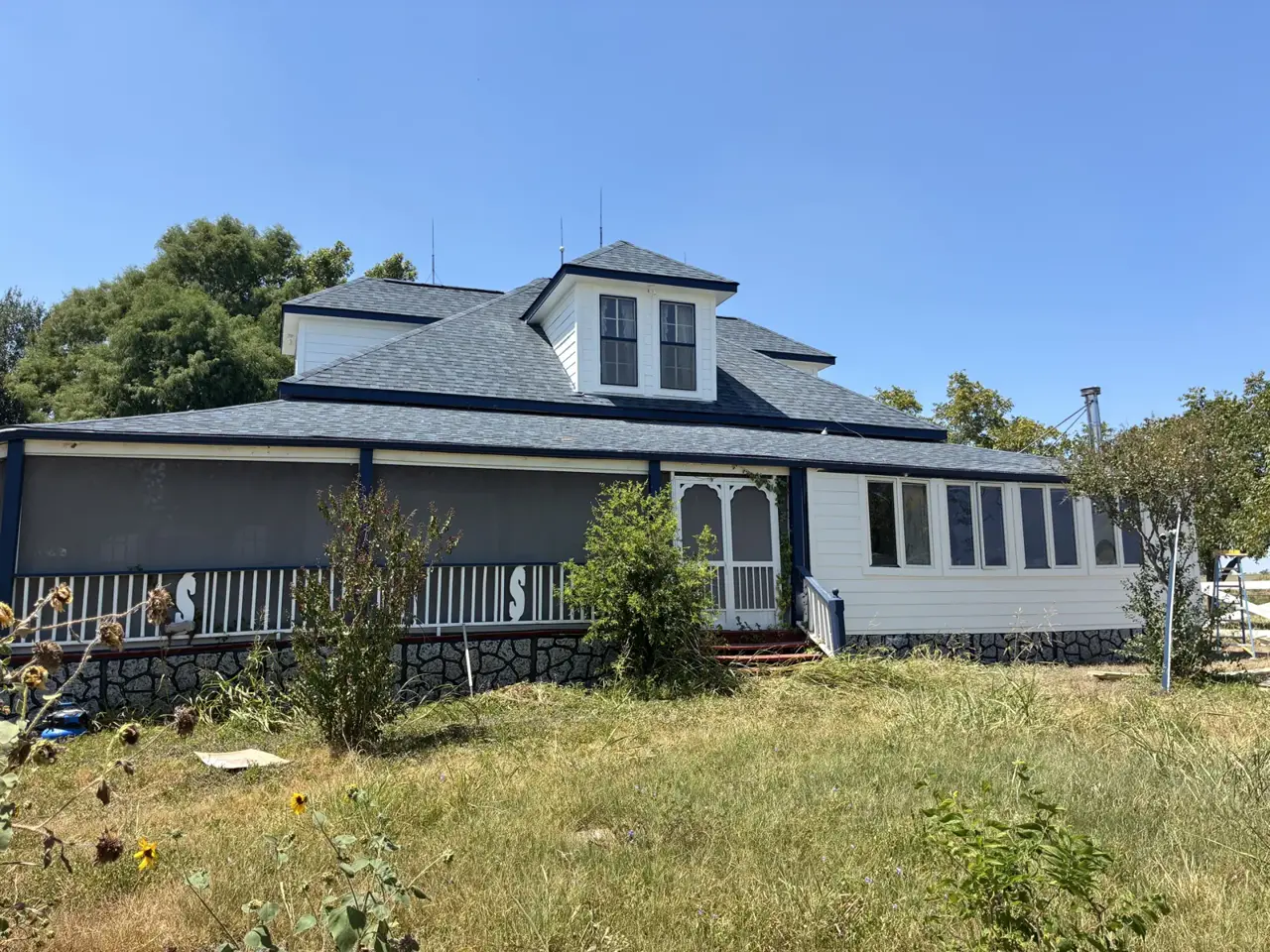 White siding around a house with a dormer and a covered porch