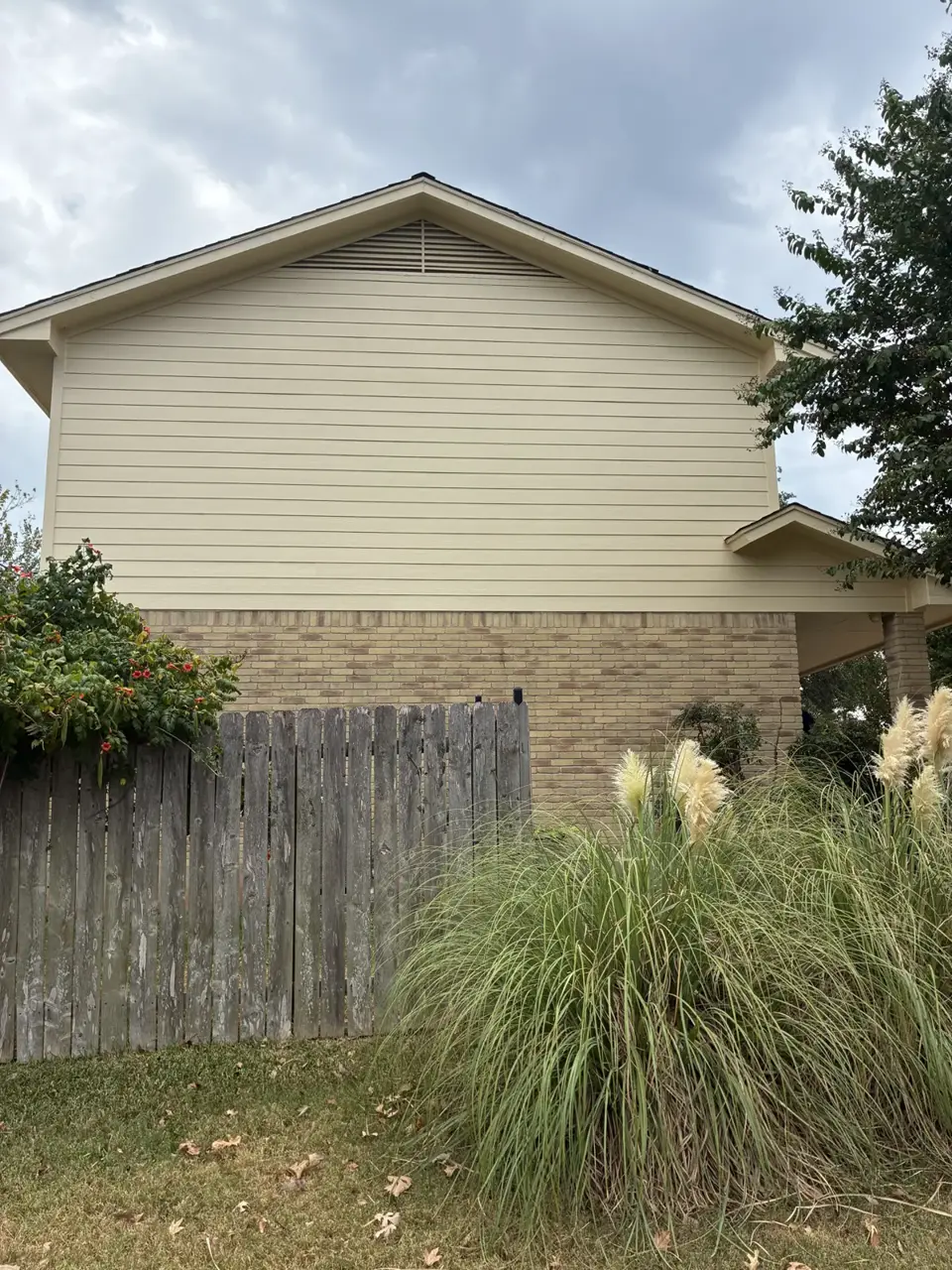 Light horizontal siding on a gable above a stone wall