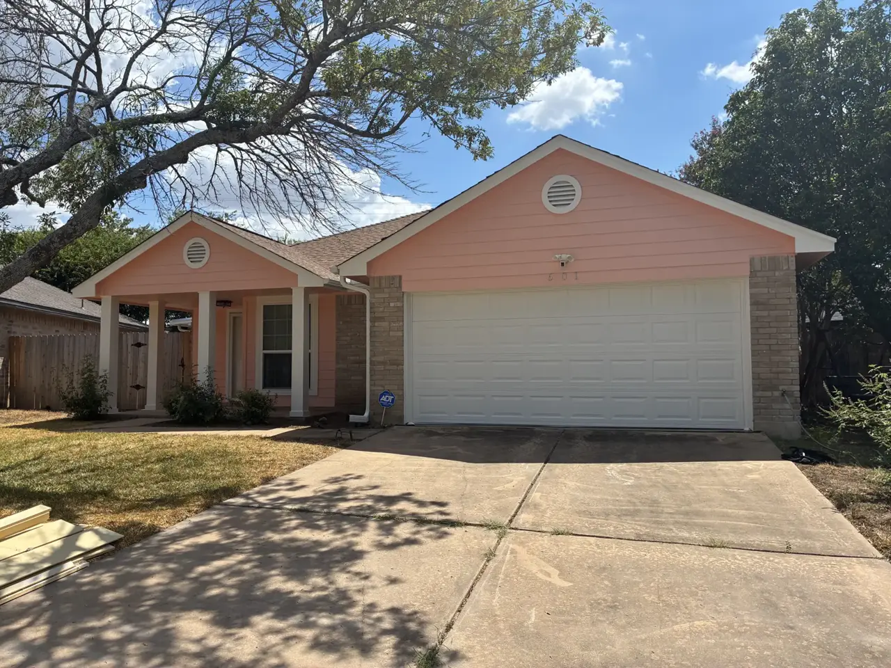 Pink house with a front porch and garage