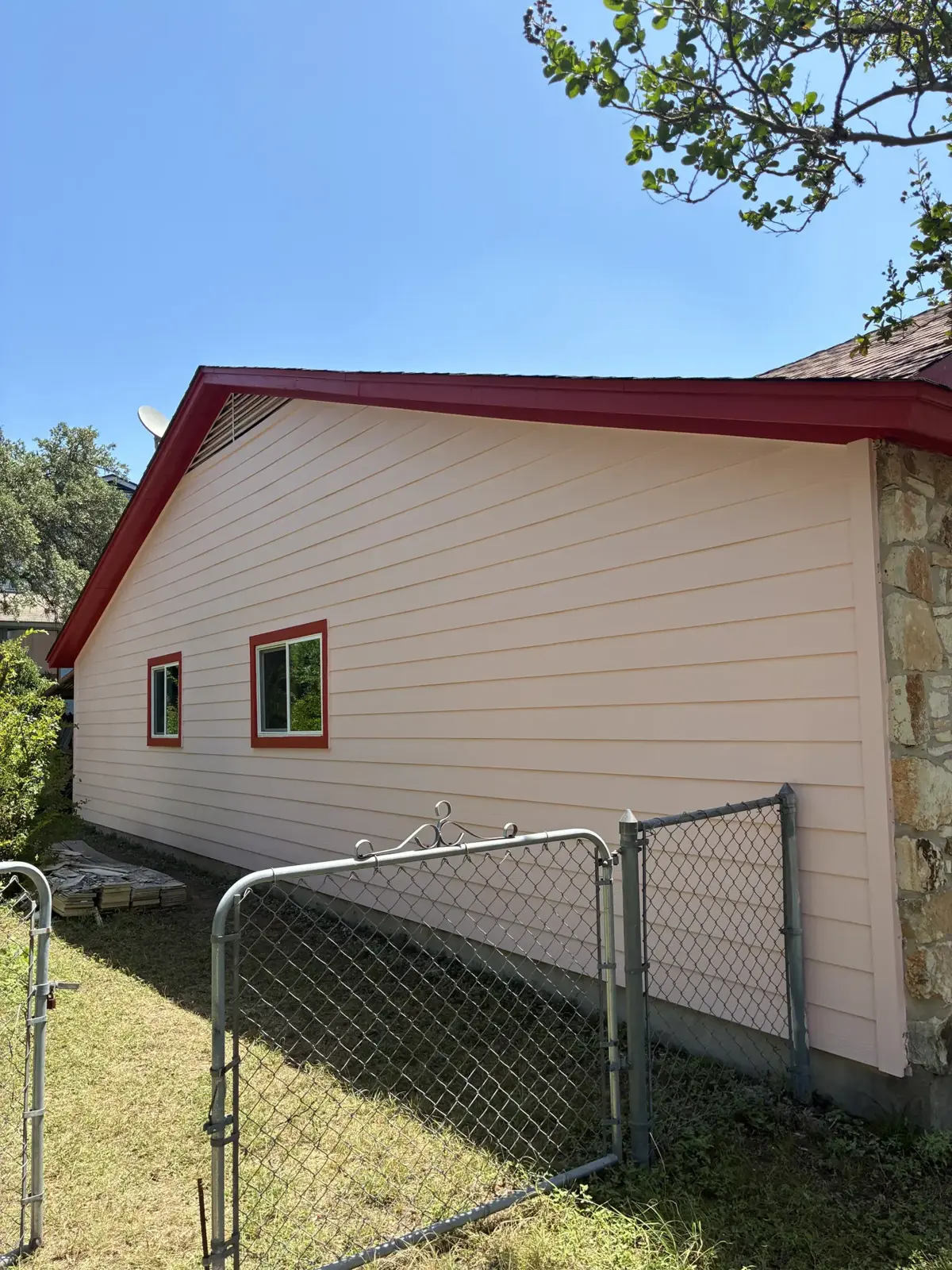 Light horizontal siding beside red roof trim