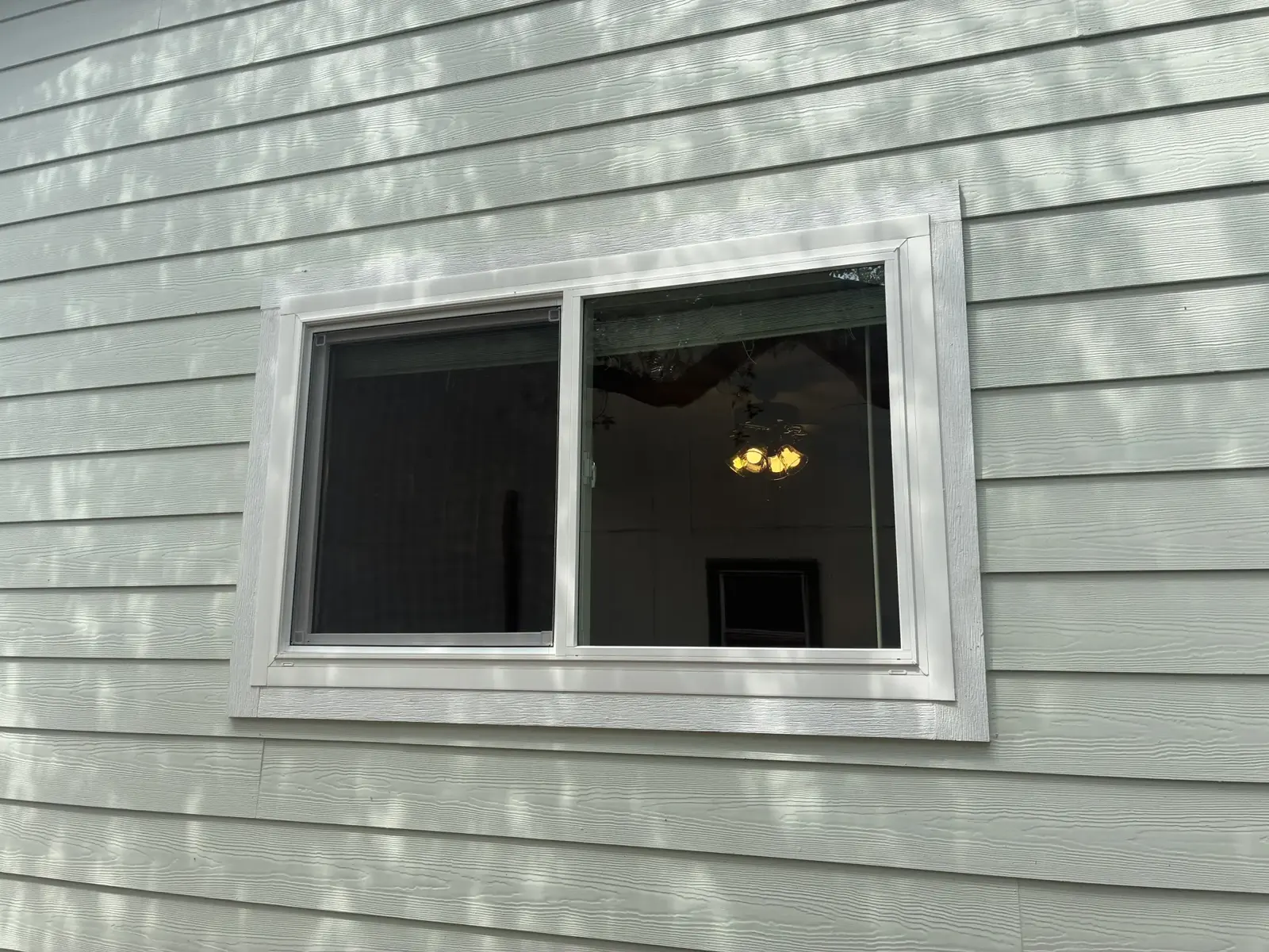 Wide rectangular window in light horizontal siding
